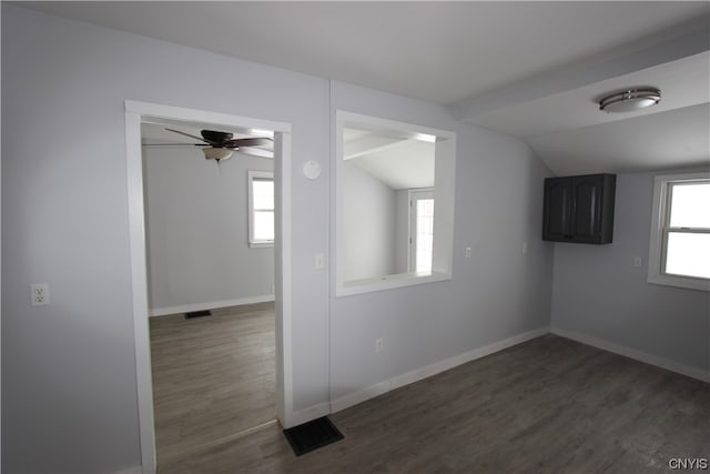 empty room with dark hardwood / wood-style flooring, ceiling fan, a healthy amount of sunlight, and vaulted ceiling