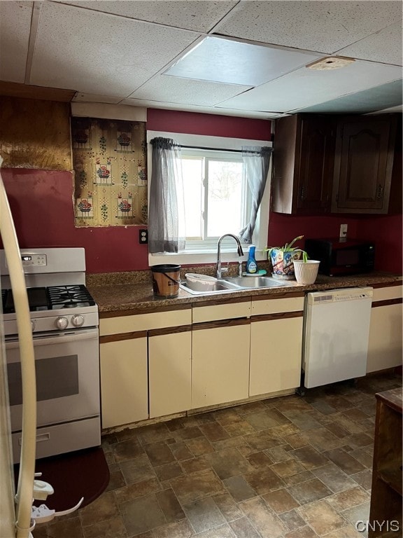 kitchen with a paneled ceiling, sink, and white appliances