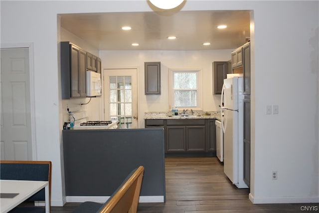 kitchen with sink, white appliances, and dark hardwood / wood-style floors