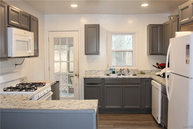 kitchen with white appliances, dark hardwood / wood-style floors, sink, and kitchen peninsula