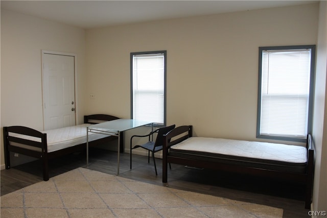 bedroom with wood-type flooring and multiple windows