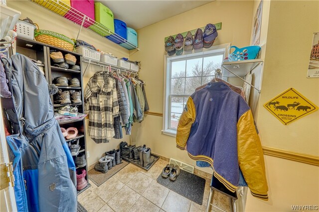 walk in closet with light tile floors