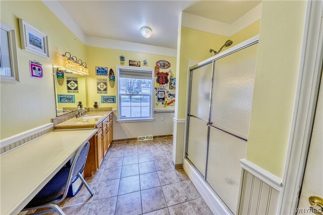 bathroom with tile flooring, large vanity, and walk in shower