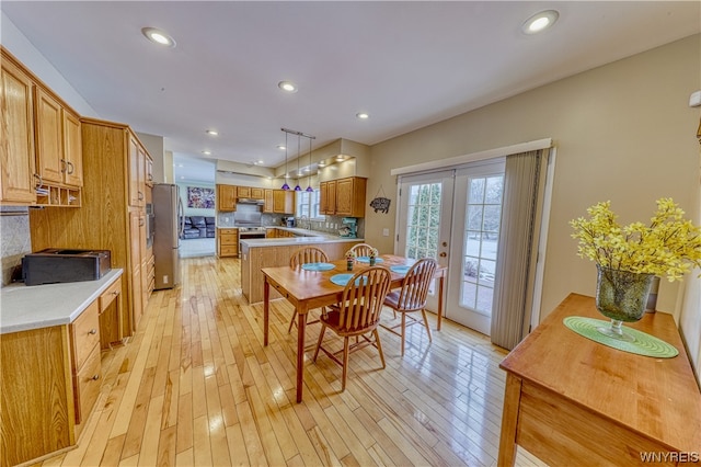 dining space with french doors, sink, and light hardwood / wood-style floors