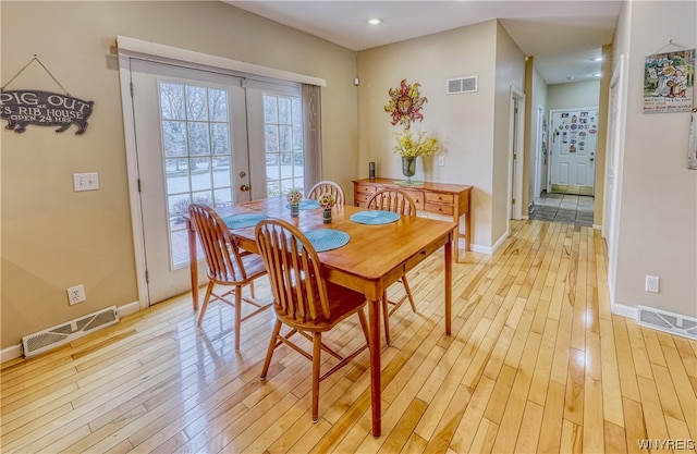 dining room featuring french doors and light wood-type flooring