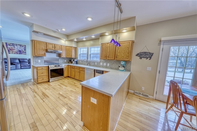 kitchen featuring light hardwood / wood-style flooring, pendant lighting, stainless steel appliances, and backsplash