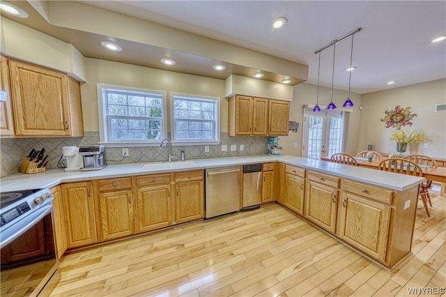 kitchen featuring pendant lighting, stainless steel dishwasher, electric range, tasteful backsplash, and sink