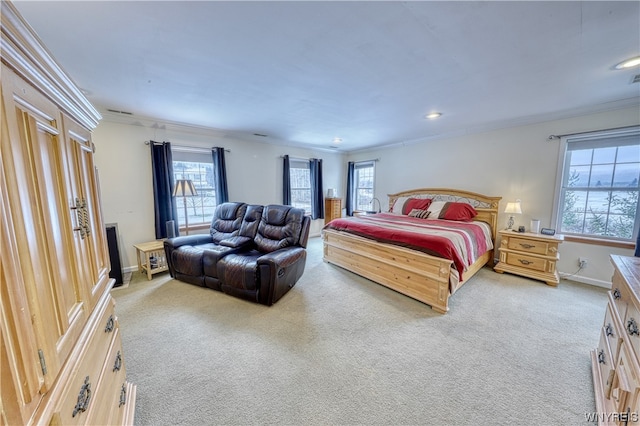 carpeted bedroom with ornamental molding and multiple windows