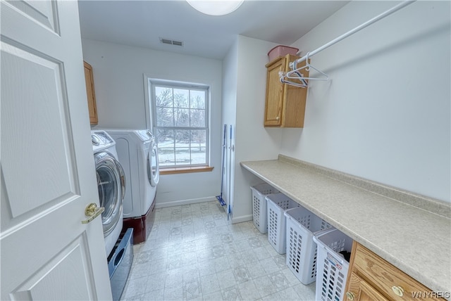 washroom featuring light tile floors, cabinets, and washer and dryer