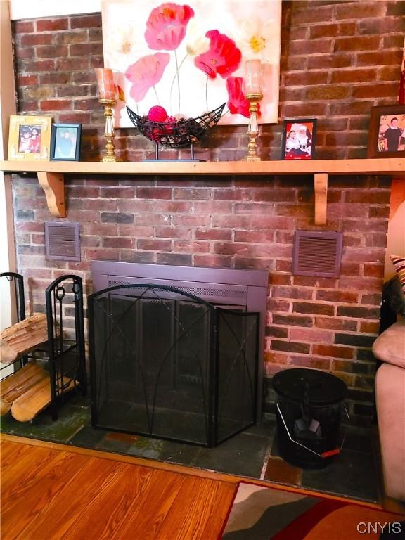 interior details with hardwood / wood-style floors and a brick fireplace