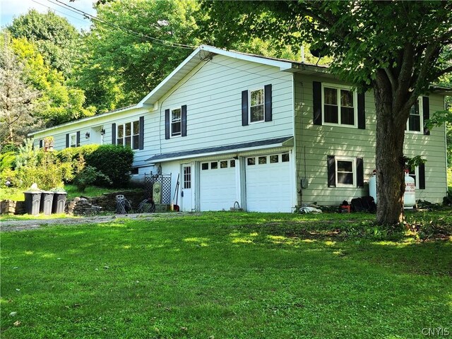 view of front of property with a garage and a front yard