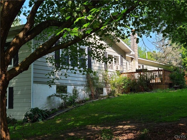 view of home's exterior with a deck and a lawn