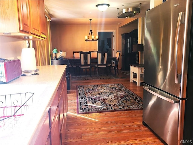 kitchen featuring dark hardwood / wood-style flooring, pendant lighting, and stainless steel refrigerator