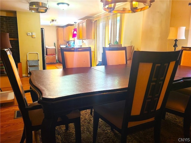 dining space featuring an inviting chandelier and light hardwood / wood-style floors