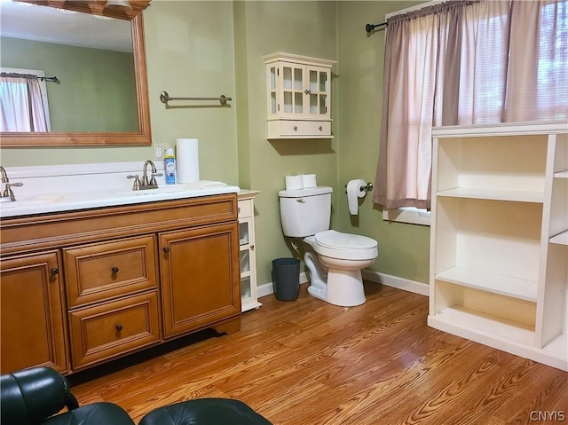 bathroom with hardwood / wood-style flooring, vanity, and toilet