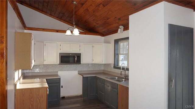 kitchen with sink, a notable chandelier, white cabinets, dark hardwood / wood-style floors, and hanging light fixtures