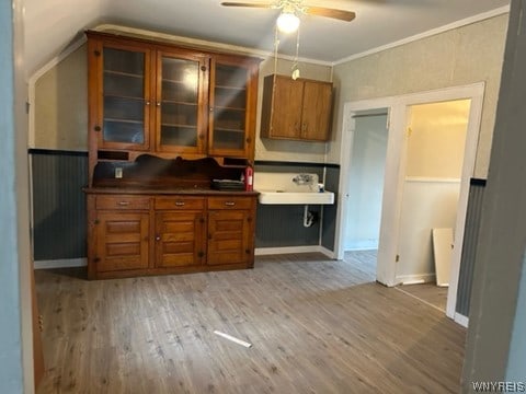 kitchen featuring lofted ceiling, ceiling fan, sink, light hardwood / wood-style flooring, and ornamental molding