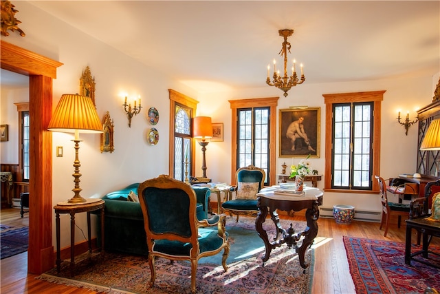 dining area with baseboard heating, a chandelier, and hardwood / wood-style flooring