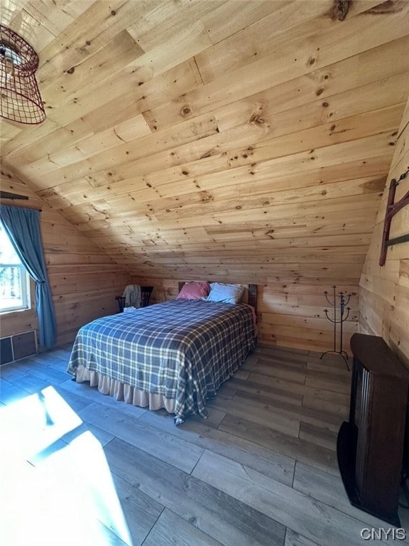 bedroom featuring wood ceiling, vaulted ceiling, light hardwood / wood-style floors, and wooden walls