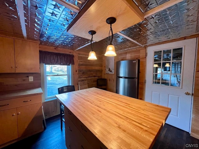 kitchen featuring pendant lighting, dark hardwood / wood-style flooring, butcher block counters, and stainless steel refrigerator