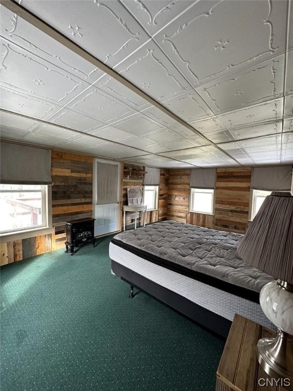 unfurnished bedroom featuring carpet, wooden walls, and multiple windows