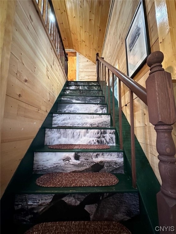 stairs with wood walls and wooden ceiling