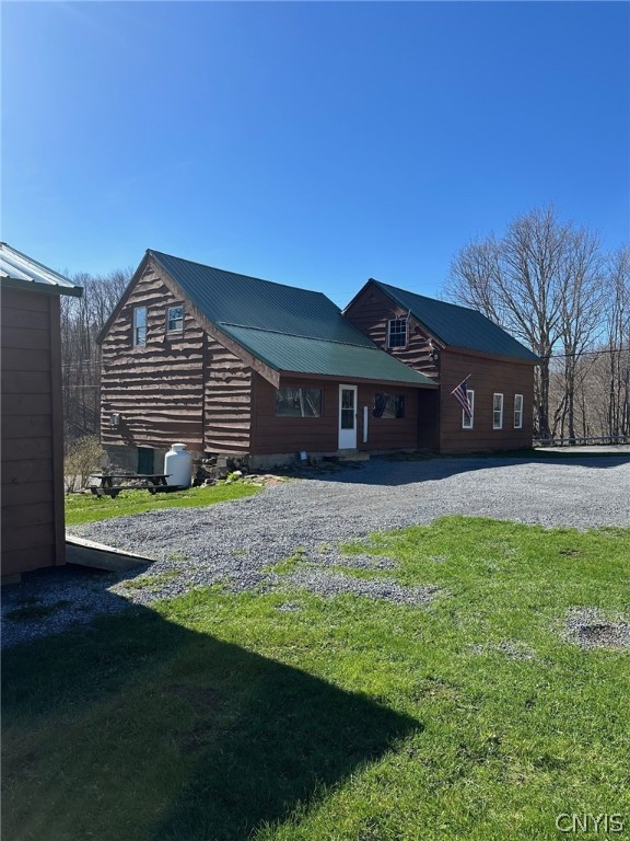 rear view of property with a lawn