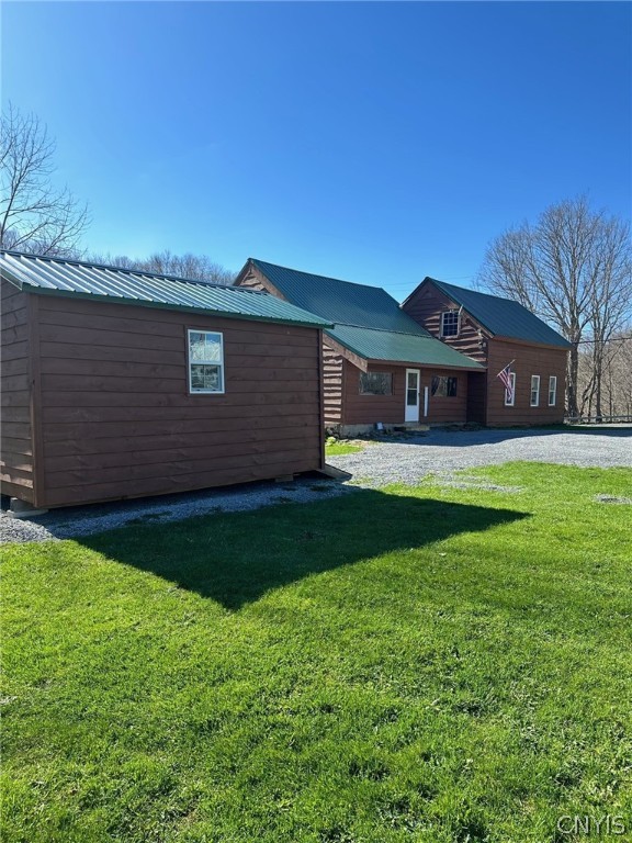 rear view of house featuring a lawn