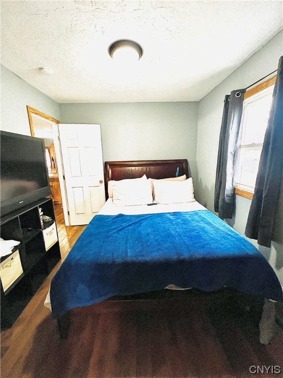 bedroom with a textured ceiling and hardwood / wood-style floors