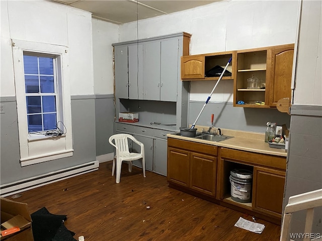 kitchen featuring baseboard heating, dark wood-type flooring, and sink