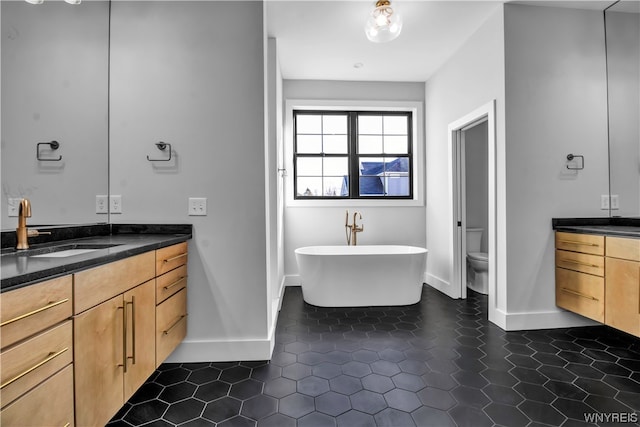 bathroom featuring vanity, tile flooring, and toilet