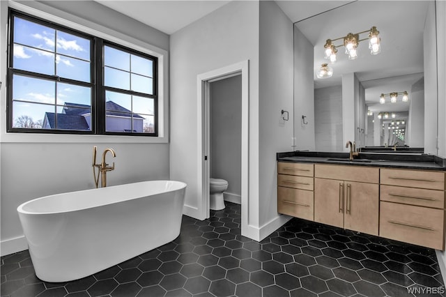 bathroom with toilet, vanity, a bath, and tile flooring