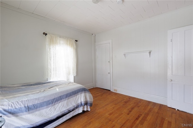 bedroom with hardwood / wood-style flooring and crown molding