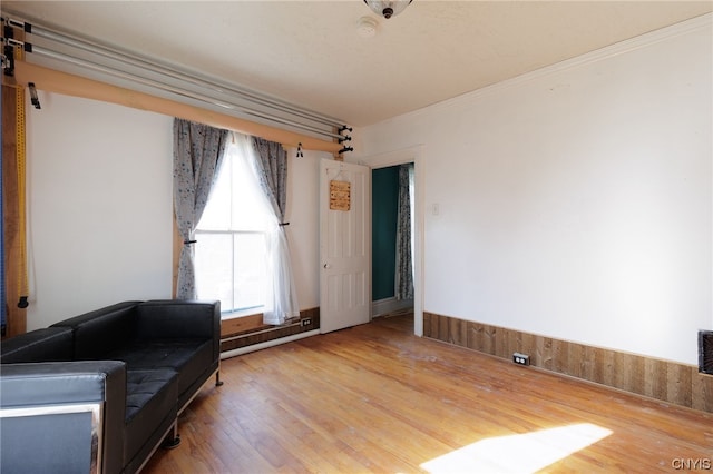 unfurnished room featuring crown molding, hardwood / wood-style floors, and a baseboard radiator