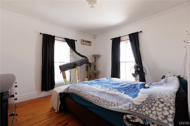 bedroom featuring ornamental molding and hardwood / wood-style flooring