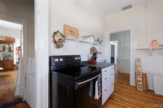 kitchen featuring ornamental molding, range with electric stovetop, white cabinets, and light hardwood / wood-style floors