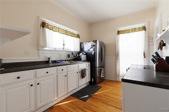 kitchen with crown molding, light hardwood / wood-style flooring, stainless steel refrigerator, and white cabinetry