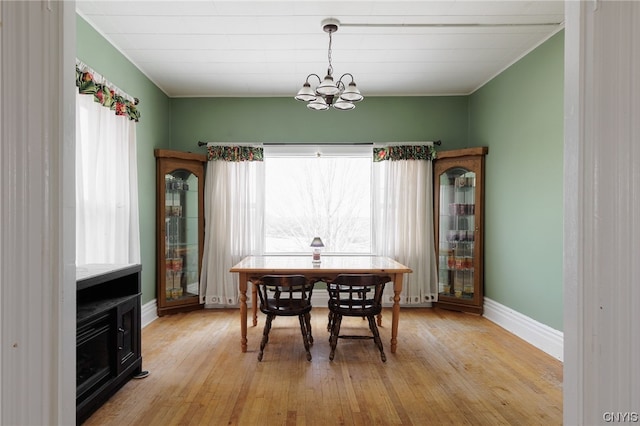 dining space featuring light wood-type flooring and a chandelier