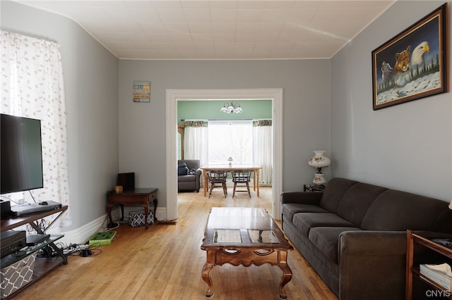 living room with crown molding and light hardwood / wood-style floors