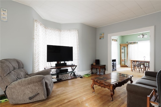 living room featuring an inviting chandelier and light hardwood / wood-style flooring