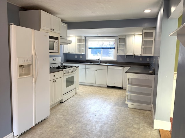 kitchen with custom exhaust hood, white cabinets, white appliances, sink, and light tile patterned floors