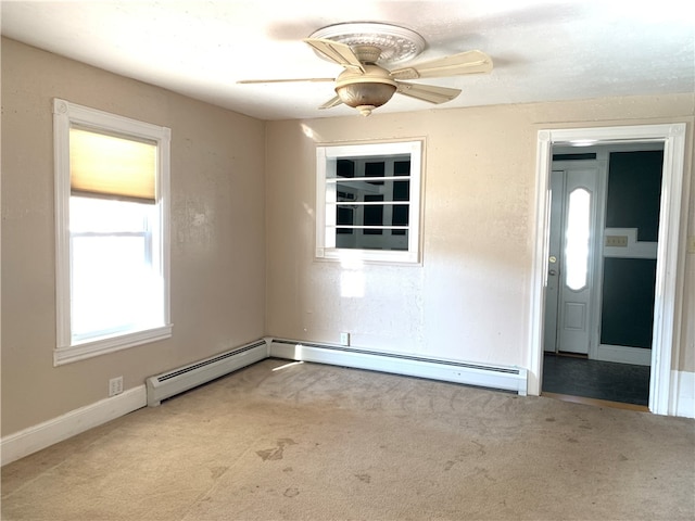 spare room featuring carpet, ceiling fan, and a baseboard heating unit