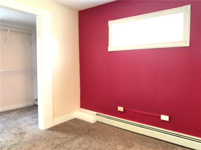 unfurnished bedroom with a closet, carpet flooring, and a baseboard radiator