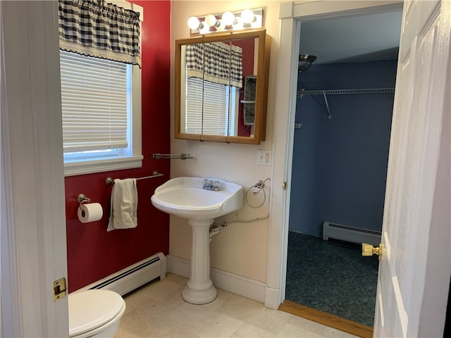 bathroom with a baseboard radiator, tile patterned flooring, and toilet