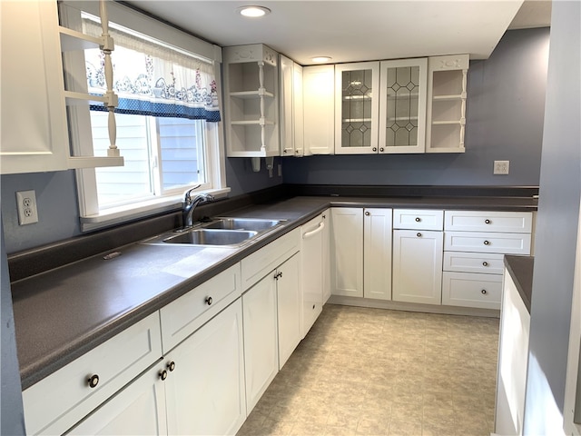 kitchen with sink, white cabinetry, dishwasher, and light tile patterned floors