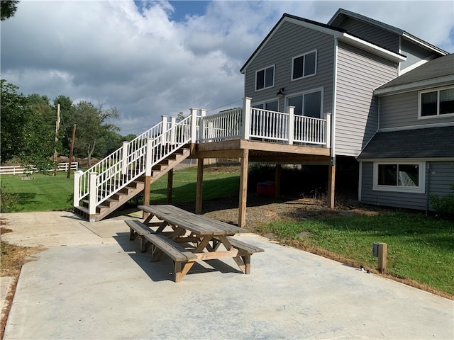 back of house featuring a deck, a yard, and a patio area