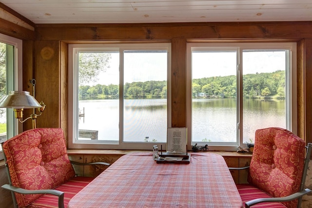 sunroom featuring a water view and wooden ceiling