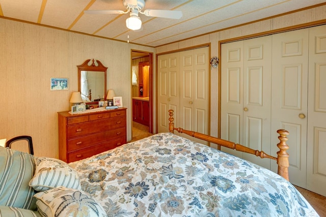 carpeted bedroom featuring multiple closets and ceiling fan