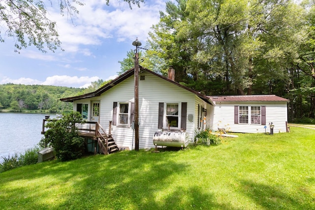 back of house featuring a water view and a yard