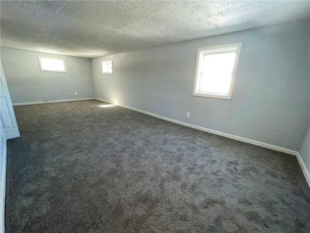 basement with dark carpet and a textured ceiling